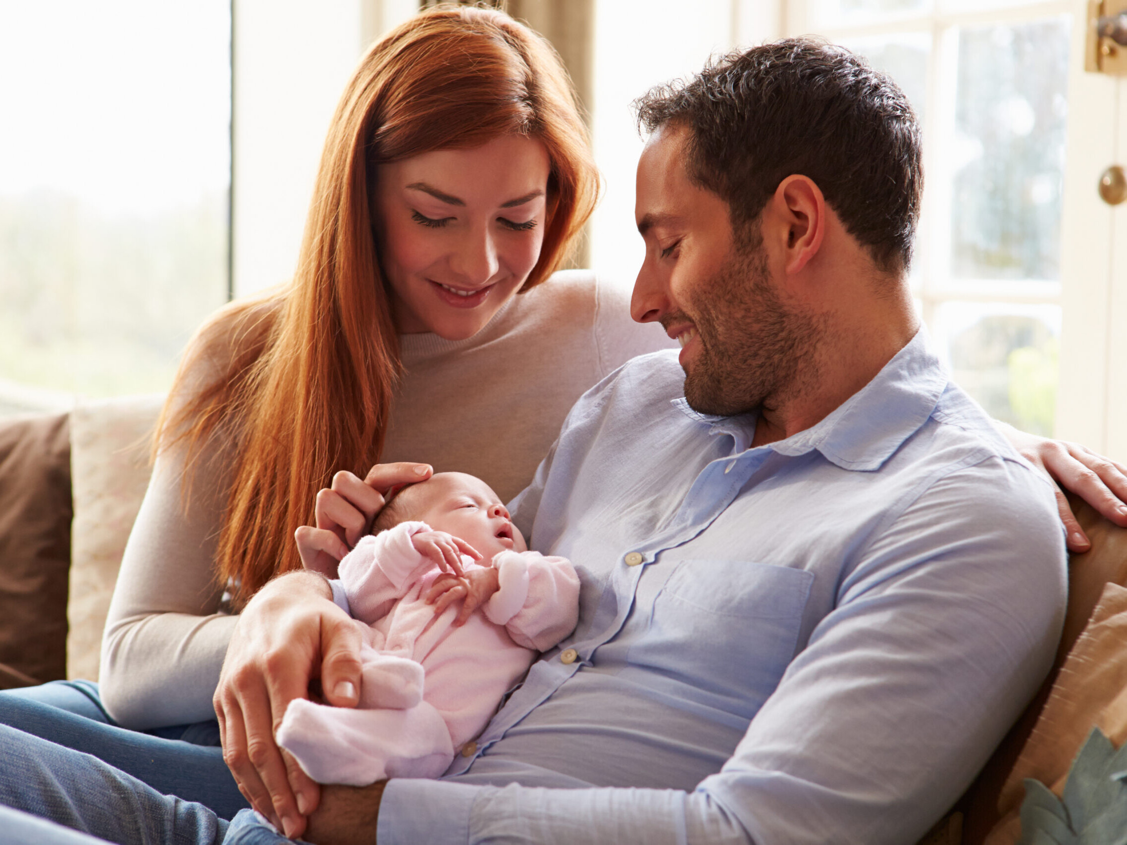 Foreldrepar sitter sammen og far holder baby.