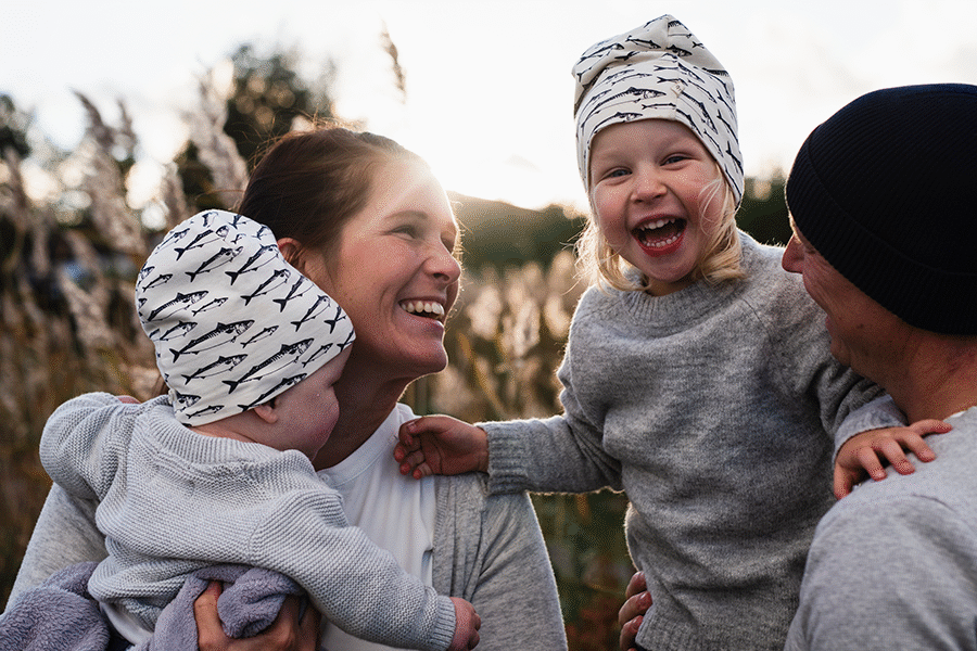 Illustrasjonsfoto for årlig LOfavør-utsendelse. Leende tobarnsfamilie utendørs